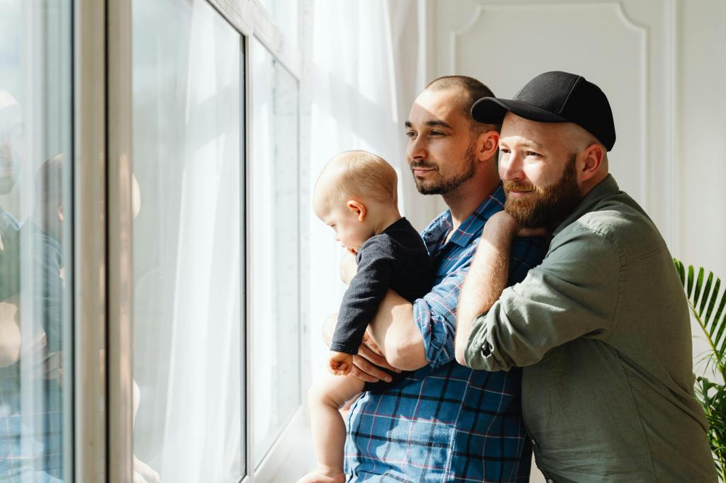 queer family looking out a window together
