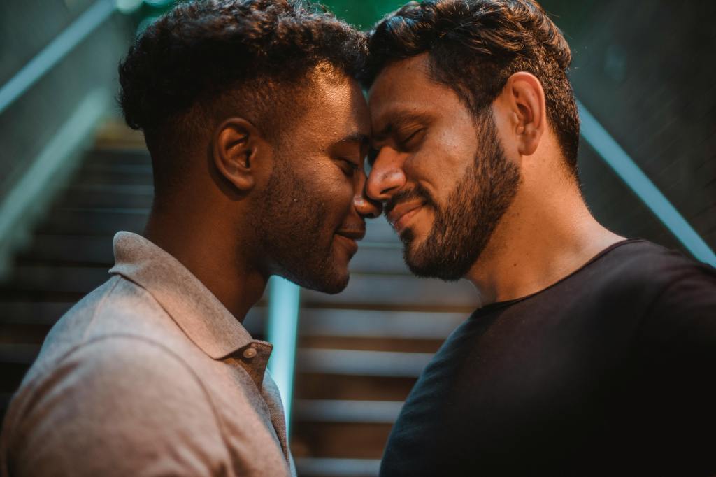 queer couple smiling, embracing